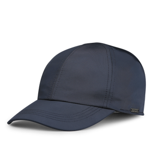 The Blue Nylon Fleece Lined Baseball Cap by Wigéns is made from technical nylon, showcasing a dark blue hue with a curved brim and a textured seam design.