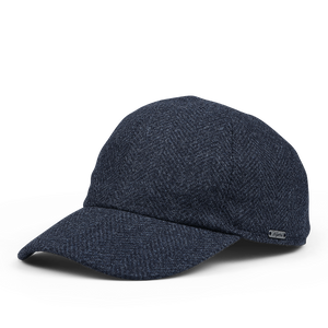 The Wigéns Dark Blue Herringbone Loro Piana Wool Baseball Cap features a textured fabric and a small metal brand tag on the side.