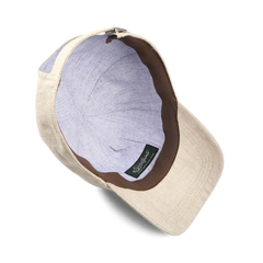 The Sand Beige Linen Baseball Cap by Wigéns features a brown and purple interior lining with an adjustable strap for the perfect fit. A label ensures authenticity.