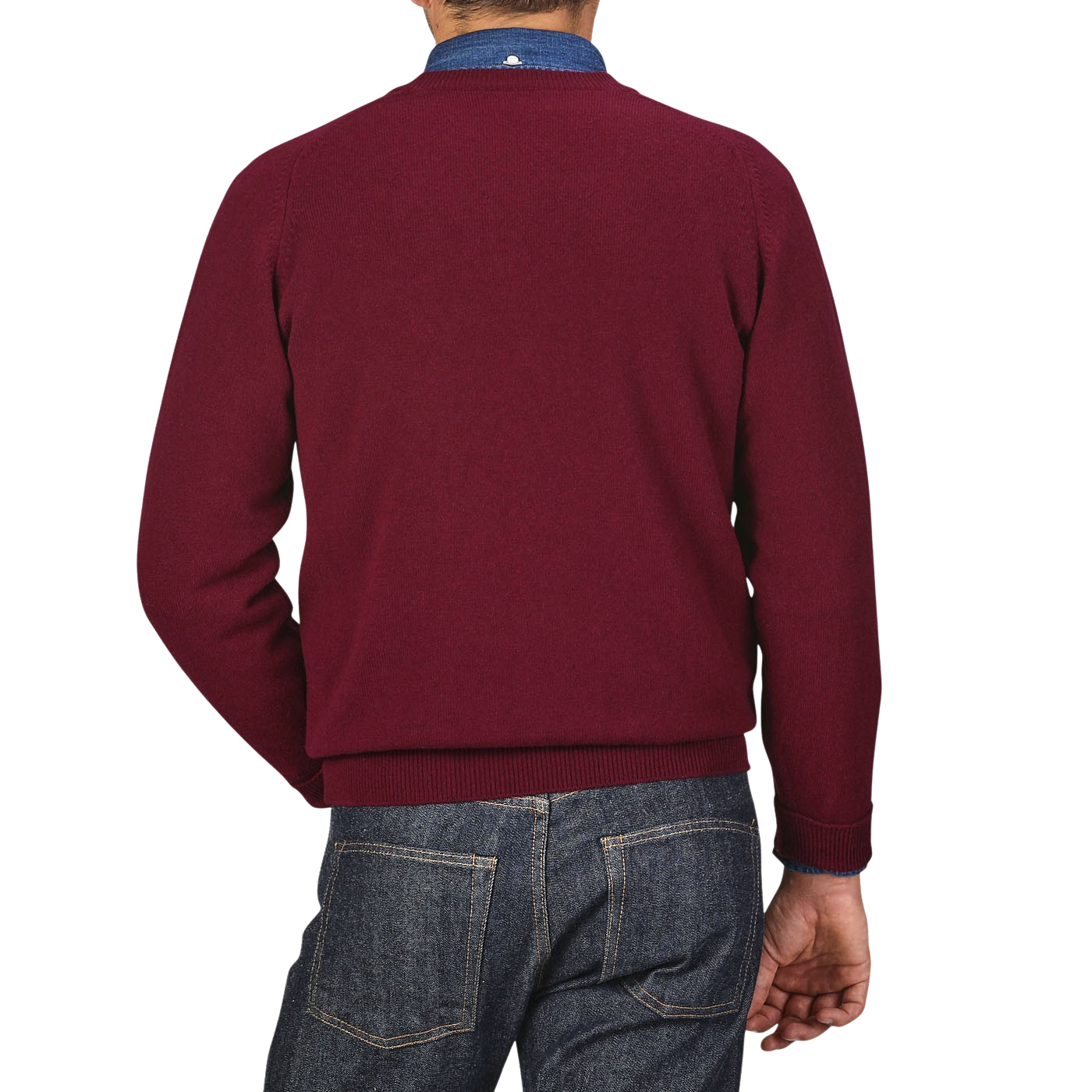 A person is seen from behind wearing a William Lockie Bordeaux Deep V-Neck Lambswool Sweater and blue jeans.