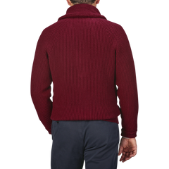 A person wearing a Bordeaux Lambswool Shawl Collar Cardigan by William Lockie and dark pants, viewed from the back against a neutral background.