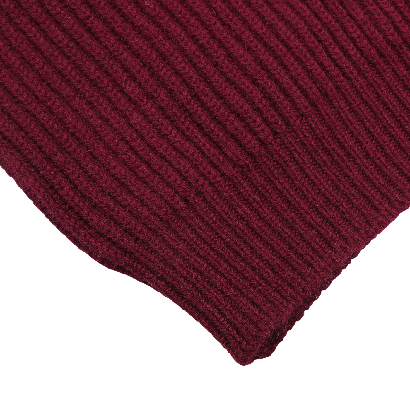 Close-up of a burgundy ribbed knit fabric with a portion of its uneven edge visible, reminiscent of the luxurious texture found in the William Lockie Bordeaux Lambswool Shawl Collar Cardigan.