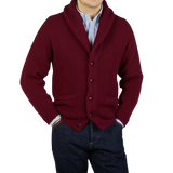 A man wearing a Bordeaux Lambswool Shawl Collar Cardigan by William Lockie and jeans.