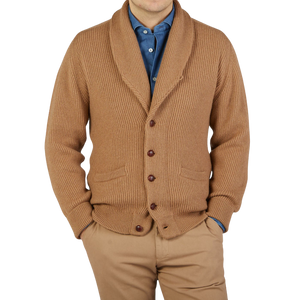 A man wearing a William Lockie Brown Camel Hair Shawl Collar Cardigan made of pure camel hair.