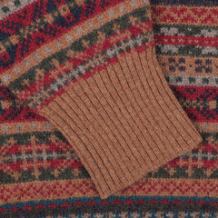 Close-up of the William Lockie Brown Fair Isle Crew Neck Lambswool Sweater, showcasing its multi-colored geometric pattern crafted from pure Scottish lambswool and featuring a ribbed brown cuff.