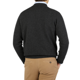 The back view of a man wearing a William Lockie Charcoal Grey Crew Neck Lambswool Sweater and tan pants.