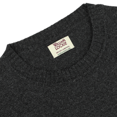 A Charcoal Grey Crew Neck Lambswool Sweater by William Lockie, featuring a label that reads "William Lockie, Dry Clean, Made in Scotland," crafted from exquisite Scottish lambswool for a smart casual look.