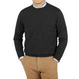 A man wearing a William Lockie Charcoal Grey Crew Neck Lambswool Sweater.