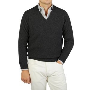 A man wearing a Charcoal Grey V-neck Lambswool Sweater made by William Lockie, creating a sophisticated business look.