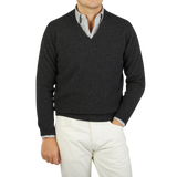 A man wearing a Charcoal Grey V-neck Lambswool Sweater made by William Lockie, creating a sophisticated business look.