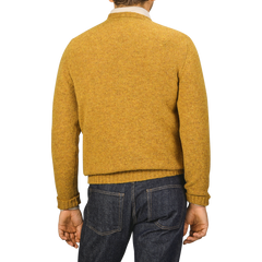 A person wearing a Cumin Brushed Shetland Lambswool Crew Neck by William Lockie, paired with dark jeans, is facing away from the camera.