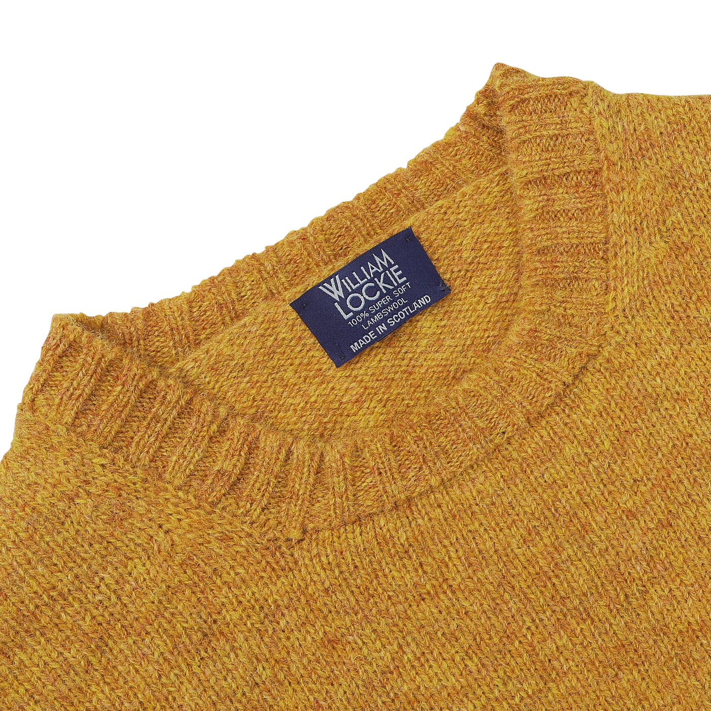 The close-up features the Cumin Brushed Shetland Lambswool Crew Neck, showcasing its exquisite wool texture. The "William Lockie" label proudly signifies its Scottish origin, reflecting the brand's commitment to quality lambswool knitwear.