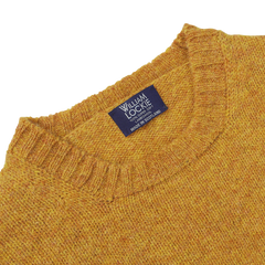 The close-up features the Cumin Brushed Shetland Lambswool Crew Neck, showcasing its exquisite wool texture. The "William Lockie" label proudly signifies its Scottish origin, reflecting the brand's commitment to quality lambswool knitwear.