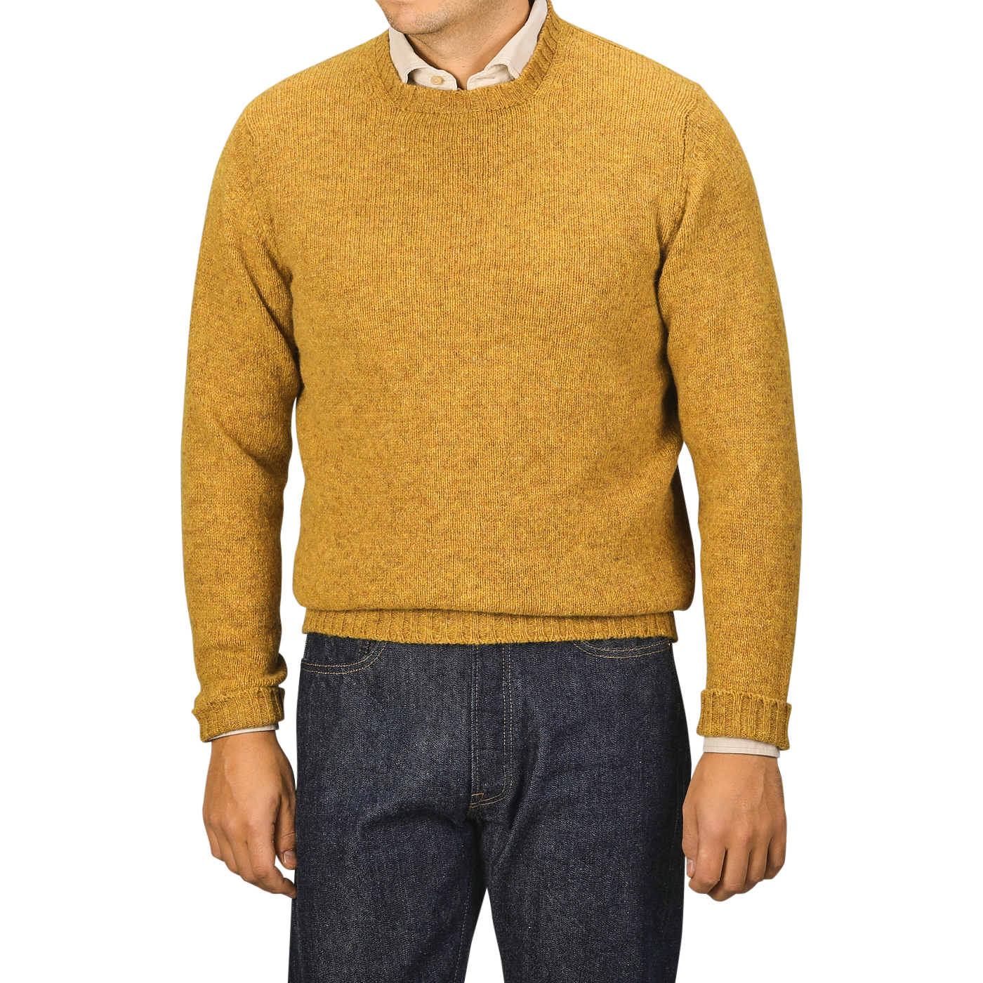 A person in a cumin yellow Cumin Brushed Shetland Lambswool Crew Neck sweater and dark jeans stands against a plain background, facing forward. This lambswool knitwear from William Lockie exudes timeless style and cozy warmth.