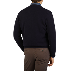 The back view of a man wearing a cozy William Lockie Dark Navy V-Neck Lambswool Sweater.