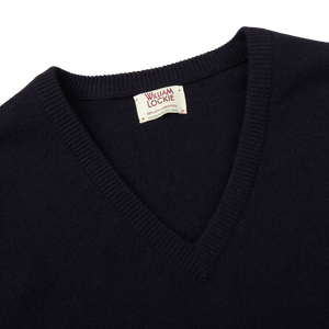 A comfy Dark Navy V-Neck Lambswool Sweater from William Lockie with a label on it.