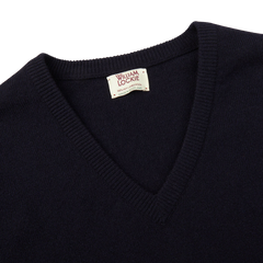 A comfy Dark Navy V-Neck Lambswool Sweater from William Lockie with a label on it.