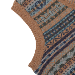 Close-up of a knitted fabric with a multicolored geometric pattern in shades of blue, driftwood brown, and green. The fabric has a ribbed edge, reminiscent of the exquisite craftsmanship found in the Driftwood Brown Fair Isle V-Neck Lambswool Slipover by William Lockie.