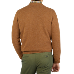 The back view of a man wearing a William Lockie Driftwood Crew Neck Lambswool Sweater and green pants.