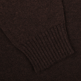 Close-up of the Ebony Brown Crew-Neck Lambswool Sweater by William Lockie, featuring a sleeve with ribbed cuffs. Perfect for smart casual knitwear occasions.