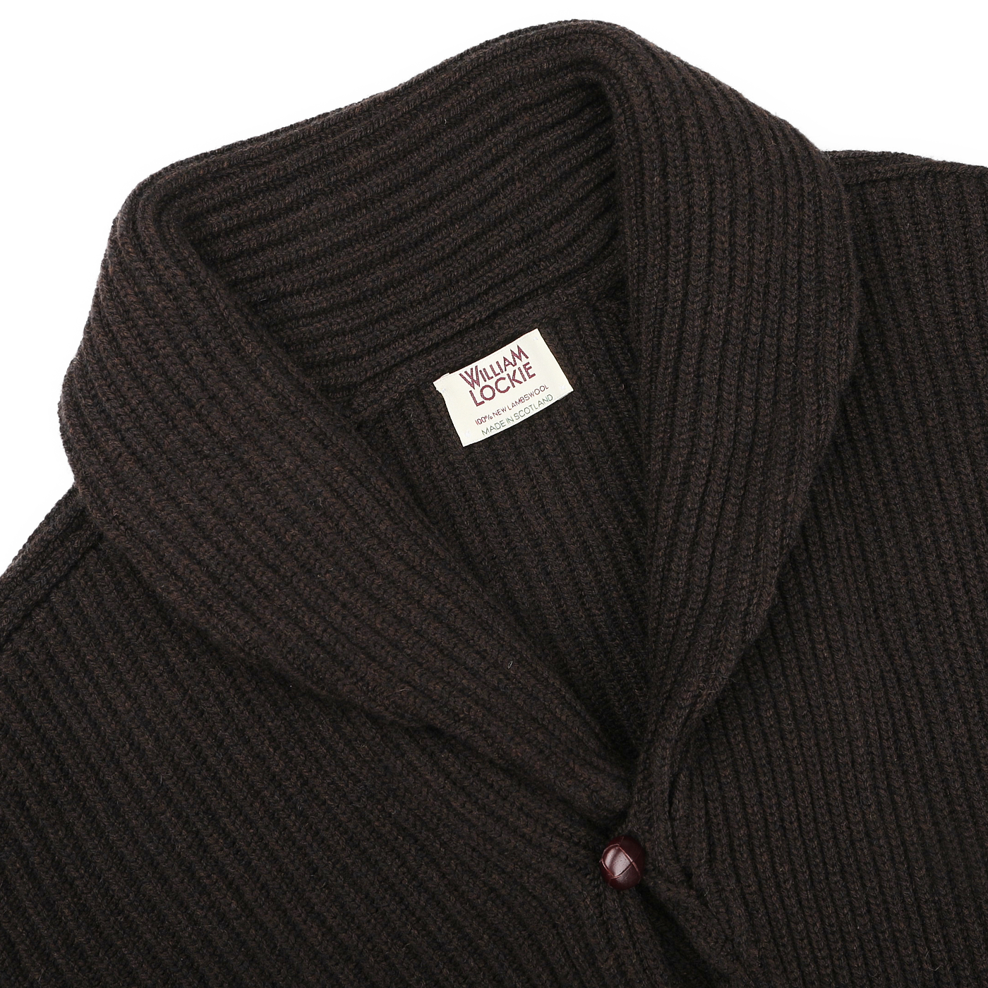 William Lockie's Ebony Brown Lambswool Shawl Collar Cardigan is expertly crafted from luxurious Scottish lambswool, showcasing a rich dark brown ribbed design, an ebony brown shawl collar, and sophisticated leather buttons, complete with a label inside.