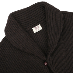 William Lockie's Ebony Brown Lambswool Shawl Collar Cardigan is expertly crafted from luxurious Scottish lambswool, showcasing a rich dark brown ribbed design, an ebony brown shawl collar, and sophisticated leather buttons, complete with a label inside.