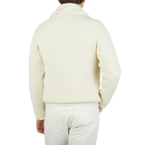 The back view of a man wearing a William Lockie Ecru Beige Lambswool Shawl Collar Cardigan with leather buttons.