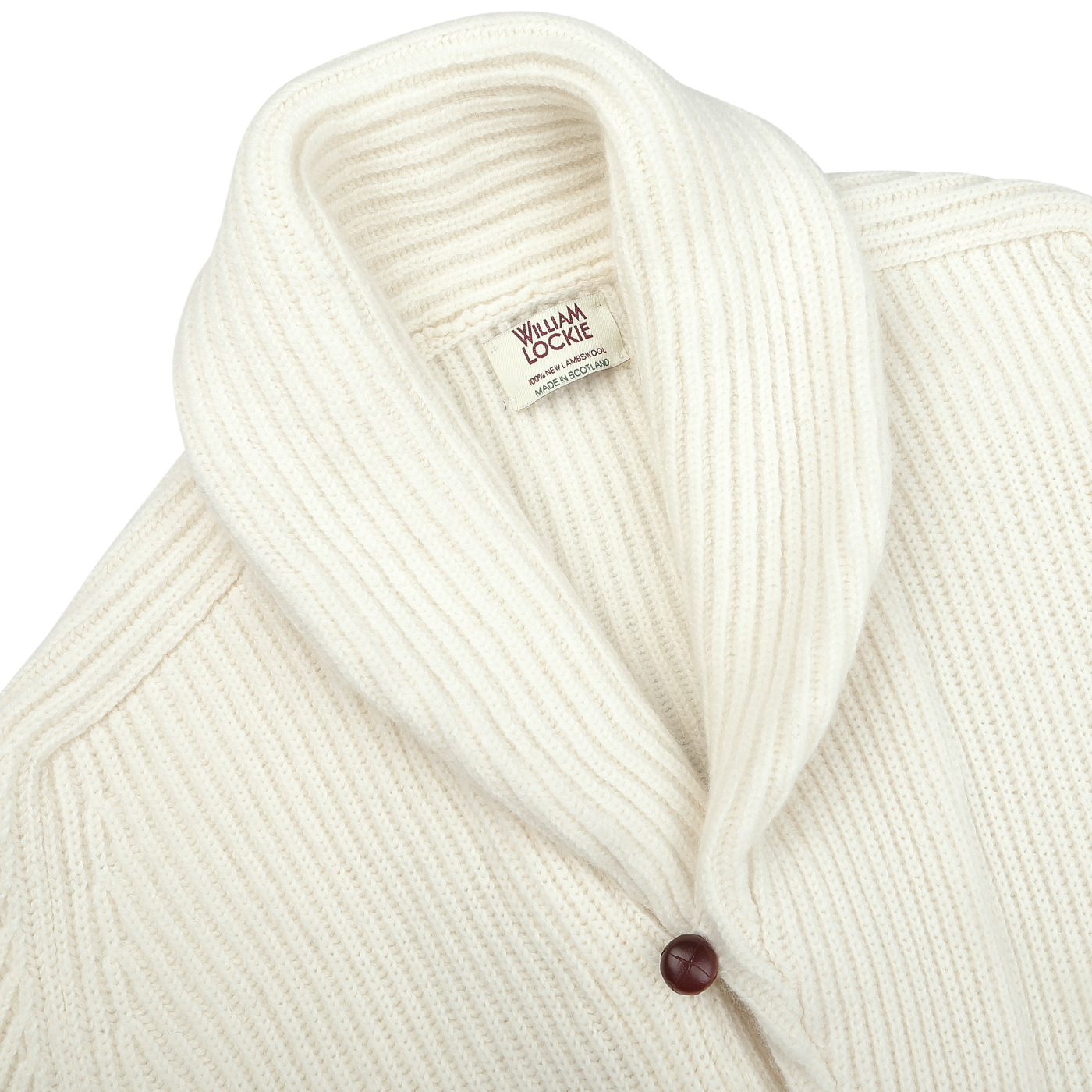 Close-up of an Ecru Beige Lambswool Shawl Collar Cardigan by William Lockie, featuring a ribbed-knit texture, a shawl collar, and a single dark button. The label inside reads "William Lockie.