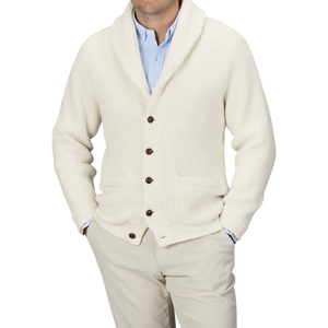 A person wearing a light blue shirt, beige pants, and an Ecru Beige Lambswool Shawl Collar Cardigan by William Lockie with leather buttons. The person's face is not visible.