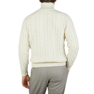 The back view of a man wearing an Ecru Cable Knit Pure Cashmere Rollneck sweater by William Lockie.