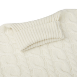 A close up of a William Lockie Ecru Cable Knit Pure Cashmere Rollneck sweater made with cashmere threads.