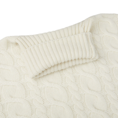 A close up of a William Lockie Ecru Cable Knit Pure Cashmere Rollneck sweater made with cashmere threads.