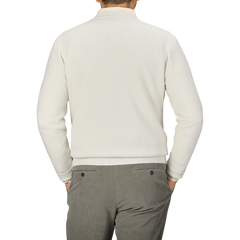 A person wearing an Ecru Crew Neck Lambswool Sweater by William Lockie and grey pants is shown from the back against a plain grey background.