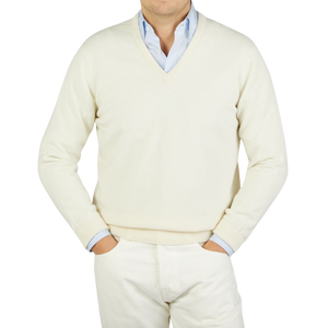 A man wearing a William Lockie Ecru White Lambswool V-Neck Sweater.