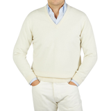 A man wearing a William Lockie Ecru White Lambswool V-Neck Sweater.