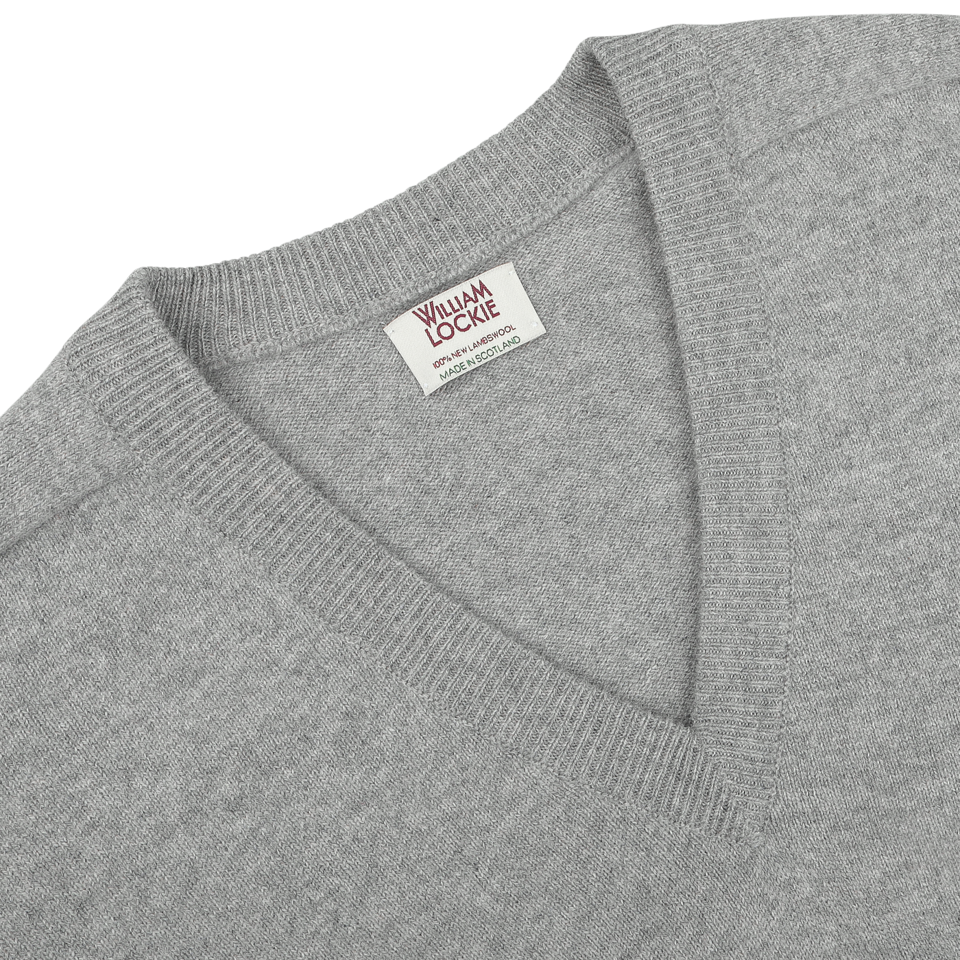 Close-up of a William Lockie Flannel Grey Deep V-Neck Lambswool Sweater, showcasing the visible brand label on the inside back collar.