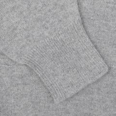 Close-up of a sleeve from the Flannel Grey Lambswool Saddle Shoulder Cardigan by William Lockie, featuring a ribbed cuff and crafted from Scottish lambswool.