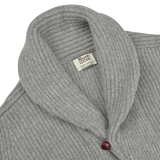 Close-up of the Flannel Grey Lambswool Shawl Collar Cardigan by William Lockie, showcasing its pure Scottish lambswool fabric, a tag labeled "William Lockie" at the neckline, and a single red leather button.