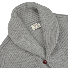 Close-up of the Flannel Grey Lambswool Shawl Collar Cardigan by William Lockie, showcasing its pure Scottish lambswool fabric, a tag labeled "William Lockie" at the neckline, and a single red leather button.