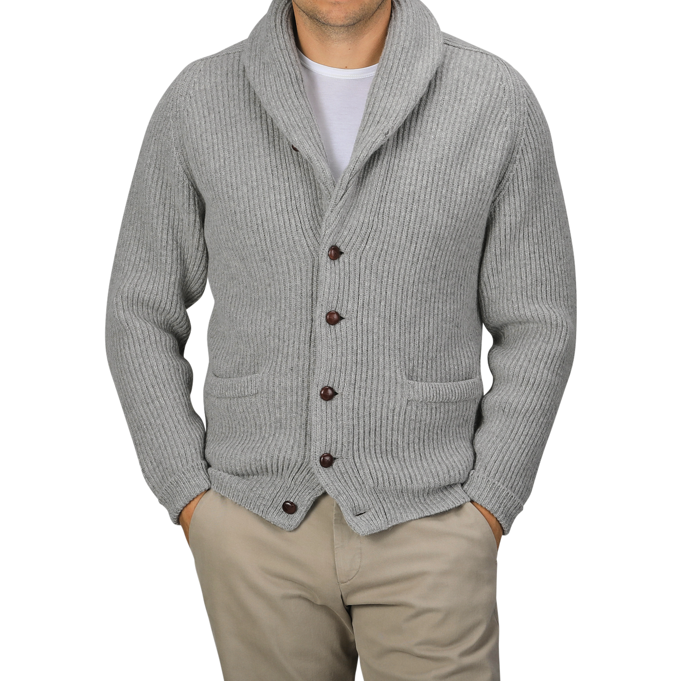 A person wearing a Flannel Grey Lambswool Shawl Collar Cardigan by William Lockie over a plain white t-shirt and beige pants, with hands in their pockets.