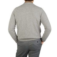 The back view of a man wearing a William Lockie Flannel Grey V-Neck Lambswool Sweater and pants.