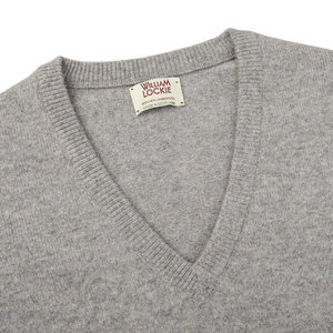 A plush Flannel Grey V-Neck Lambswool Sweater, crafted from luxurious Scottish lambswool, with a small William Lockie label accent.