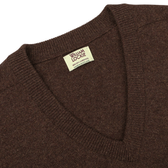 A close-up of the Hickory Brown Deep V-Neck Lambswool Sweater with a label inside the collar that reads "William Lockie, Made in Scotland.