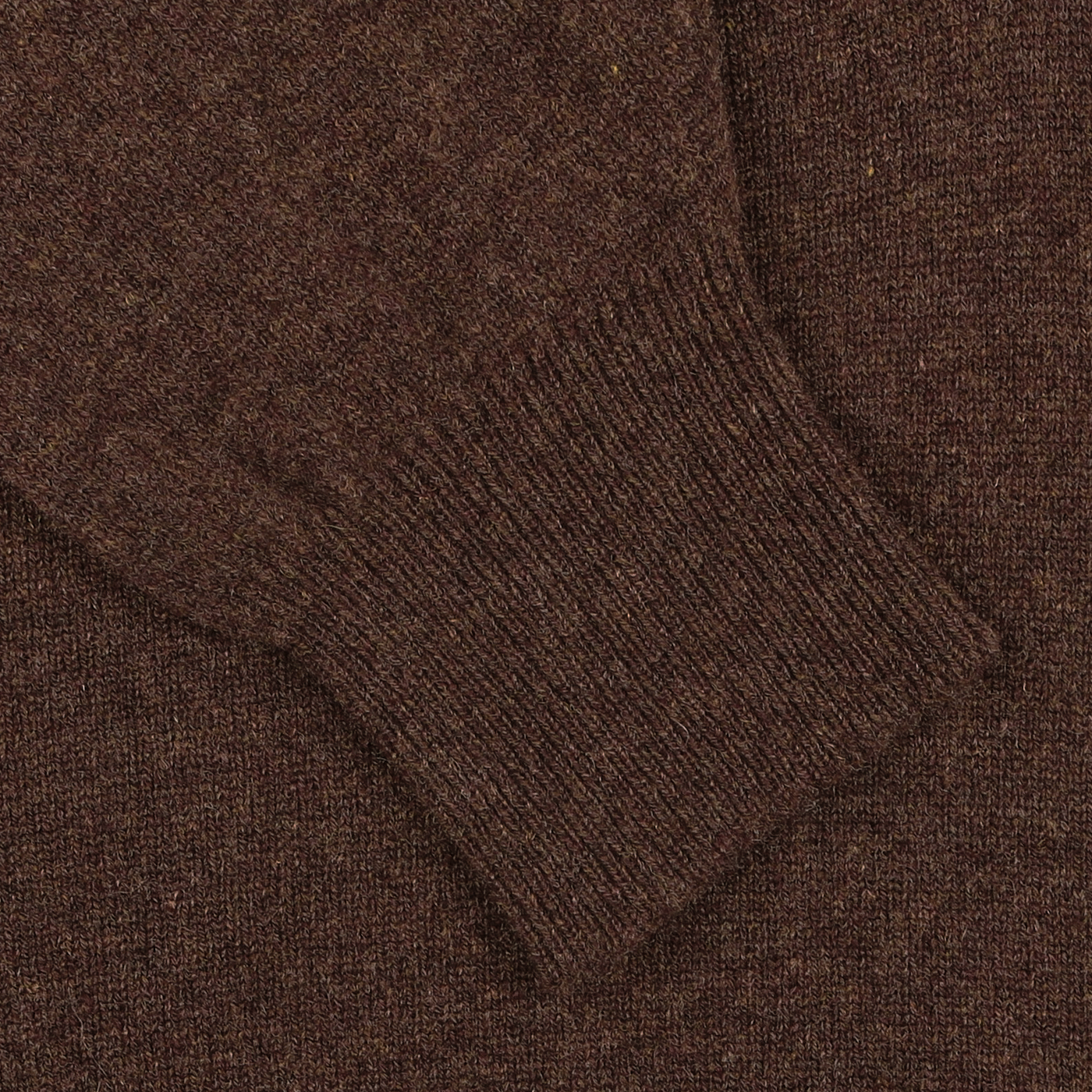 Close-up of the sleeve from the William Lockie Hickory Brown Deep V-Neck Lambswool Sweater, featuring a ribbed cuff detail.