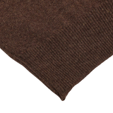 Close-up of the corner of a hickory brown knitted fabric piece, part of the William Lockie regular fit Hickory Brown Deep V-Neck Lambswool Sweater, showing the texture and weave pattern clearly.