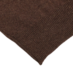 Close-up of the corner of a hickory brown knitted fabric piece, part of the William Lockie regular fit Hickory Brown Deep V-Neck Lambswool Sweater, showing the texture and weave pattern clearly.