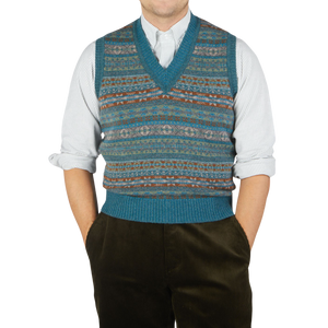 A man wearing a William Lockie Hunter Blue Fair Isle V-Neck Lambswool Slipover and pants.