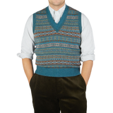 A man wearing a William Lockie Hunter Blue Fair Isle V-Neck Lambswool Slipover and pants.