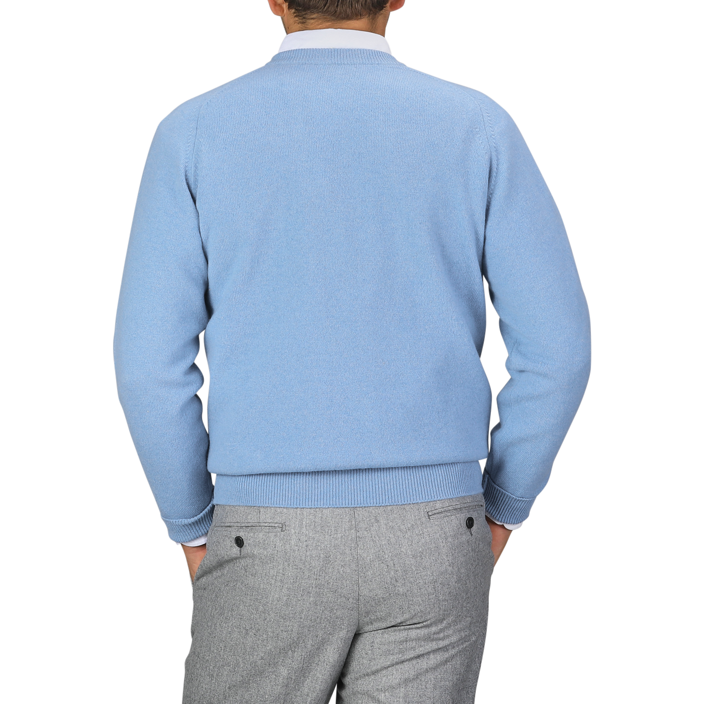 A person wearing a William Lockie Iceberg Blue Deep V-Neck Lambswool Sweater and gray pants is facing away from the camera against a plain background.