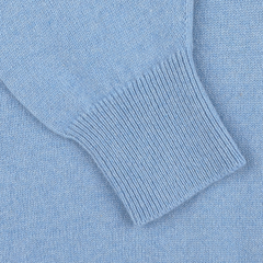 Close-up of a light blue knitted sweater sleeve with a ribbed cuff detail, part of the iceberg blue, regular fit deep V-neck lambswool sweater by William Lockie.